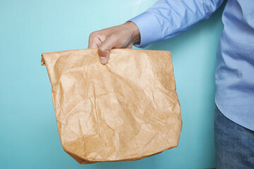  hand holding a paper lunch packet close up 