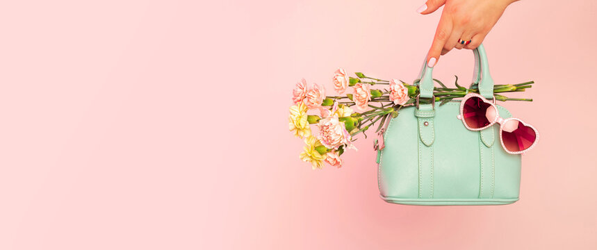 Fashion spring accessories banner - mint handbag (purse) and heart shaped sunglasses on pastel pink.