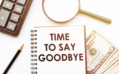 Time To Say Goodbye text on notebook with calculator, pencil, money and magnifier on the white...