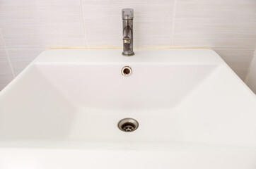 The ceramic sink basin with the stained faucet.