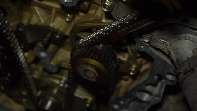 The structure of the gas distribution mechanism of the internal combustion engine, including the chain, pulleys, gears, chain tensioning mechanism. Slow motion.
