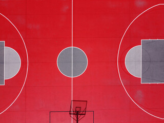 Partial overhead drone view of a red and gray basketball court