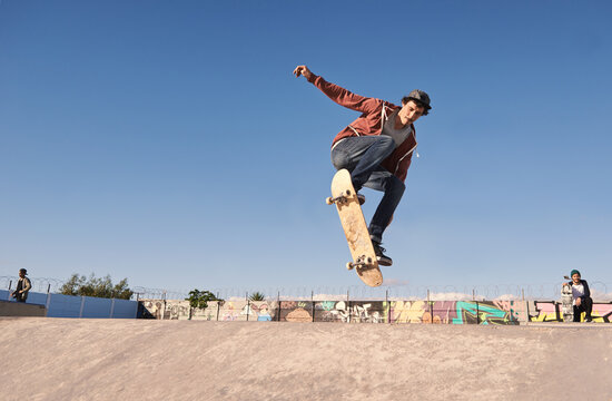 Getting some air. A young man doing tricks on his skateboard at the skate park.