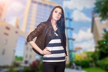 Fototapeta premium Happy young woman dressed in casual posing at city enjoys spare time.
