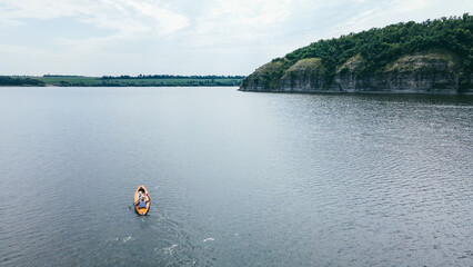 A man with a dog happy together in a canoe floats on the river in the highlands