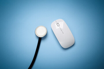 Pc mouse with stethoscope on blue background
