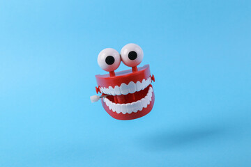 Levitating clockwork jaw on blue background with shadow. Minimalism still life