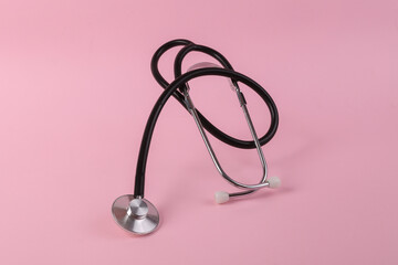 Medical stethoscope on pink background close up