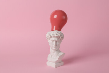 Antique David bust with pink light bulb on pink background. Conceptual pop. Minimal still life....