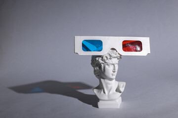 Antique bust of David with 3d glasses on gray background. Conceptual pop. Minimal still life....