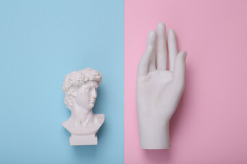 David bust with on hand on pink blue background. Creative layout. Concept pop. Minimal still life....