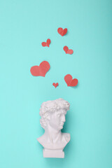 David bust with hearts on blue background. Creative love layout. Concept pop. Minimal still life. Flat lay. Top view
