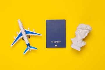 David bust with passport and air plane on yellow background. Minimal still life. Travel concept....