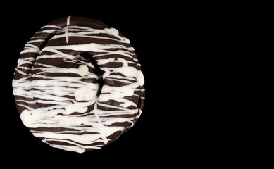 bun covered with chocolate, dark and white, on a black background