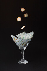 Money Cocktail business concept toast with falling gold coins money in motion.