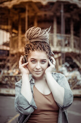Extraordinary woman with African braids and flamboyant makeup spends time in an amusement park