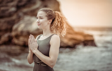 Yoga for relaxation. Beautiful woman doing namaste mudra at sea