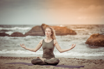 Young yogi woman meditates on the beach. Harmony, balance
