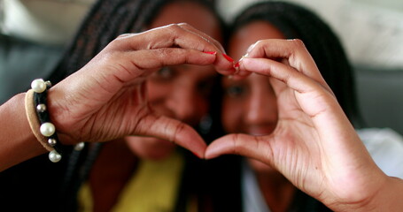 People doing heart symbol with hands. African black ethnicity, love and caring concept