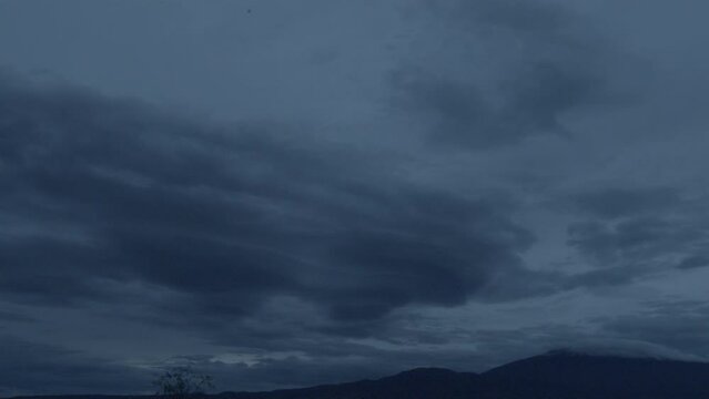 Cludy Sky slowly moving at dusk between mountains
