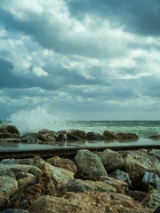 Waves crushing on rocks on a pier