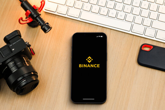 Binance cryptocurrency exchange app on smartphone iPhone 13 screen on wooden table. Content creator environment with keyboard, camera and mic. Rio de Janeiro, RJ, Brazil. March 2022