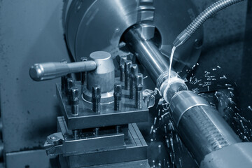 The lathe machine cutting  the metal  shaft parts with water base coolant method.
