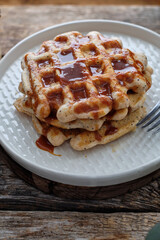 Waffles with caramel sauce. Wooden background. Top view. 