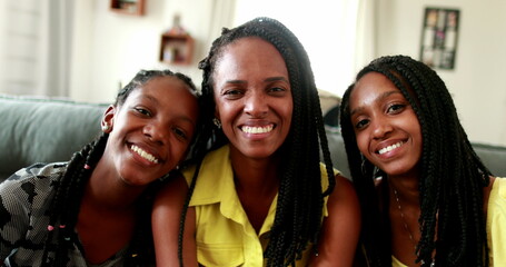 Fototapeta premium Mother and teenager daughters, family love and affection. African ethnicity