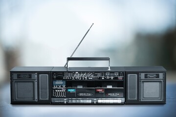 Fototapeta premium Retro boombox ghetto blaster outdated portable radio receiver with cassette recorder on the desk