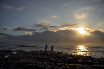 Seascape view with people fishing from the shore line on the South Coast of South Africa