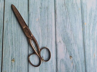 Old scissors on an old wooden table, top view. Space for Text.