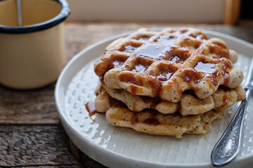 Waffles with caramel sauce. Wooden background. Top view. 