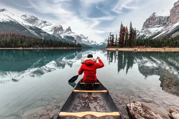 Crédence de cuisine en plexiglas Canada Male traveler in winter coat canoeing in Spirit Island on Maligne Lake at Jasper national park