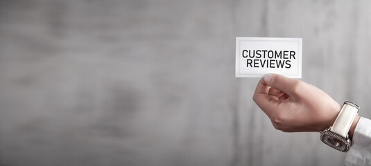 Human hand showing Customer Reviews message on business card.