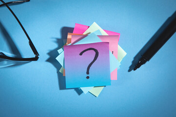 Question mark on colorful sticky notes with marker.