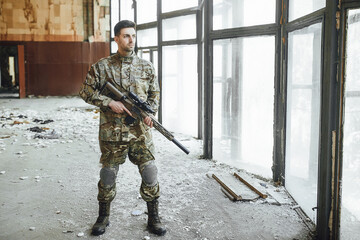 Strong military soldier patrols destroy building with a big gun.