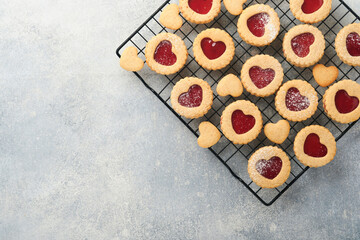Traditional Linzer cookie with strawberry jam and powder sugar on light grey beautiful background. Top view. Traditional homemade Austrian sweet dessert food on Valentines Day. Holiday snack concept.