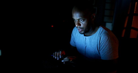 Man working late at night typing on computer laptop in the dark © Marco