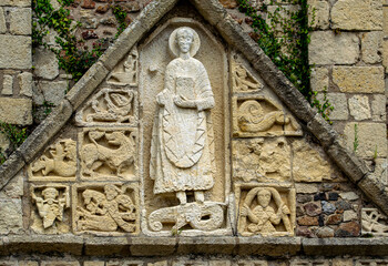 Vendée;France,28 June 2021:Triangular pediment of the portal of the Saint Nicolas church, the statue of Saint Nicolas surrounded by several mysterious motifs dating from 1020.