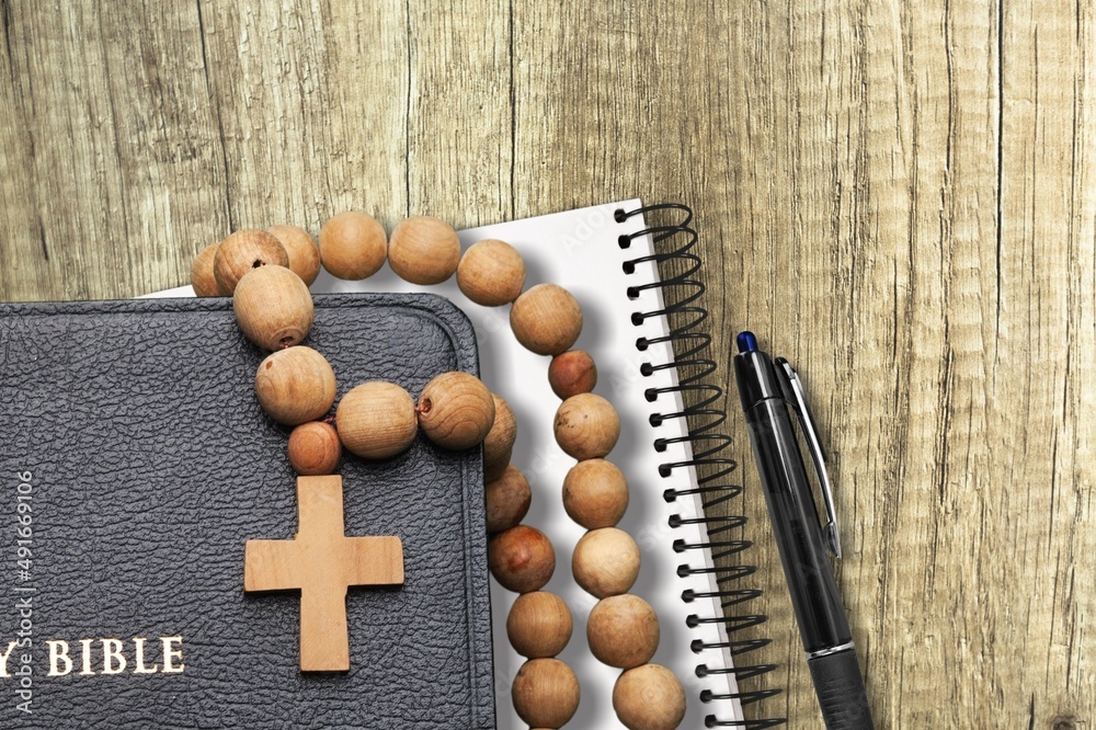 Wall mural holy bible with note book on table for christian devotion