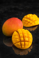 Macro shot of the fresh mango tropical fruit cut in cubes on the dark background