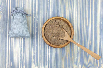 Dry ground grass and seasoning (spices) in a wooden bowl. Healing herbs.