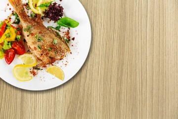 baked fish steak with mustard, lemon, rosemary on a plate