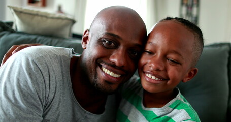 Father and son love and affection. Parent kissing and hugging little boy child. Mixed race African ethnicity