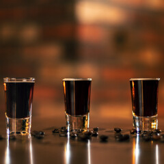 four alcohol coffee shot and coffee beans on the wooden table cube