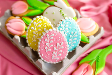 background banner greeting card for Happy Easter with set colorful eggs, Easter cake and flowers tulips gingerbread cookies in egg box on pink silk fabric background, flat lay food banner