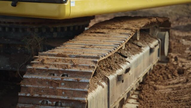 Excavator moving backward, a close up of the track.