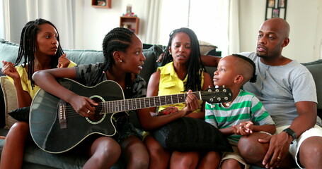 Family enjoying music together, joyful African black parents and children bonding together