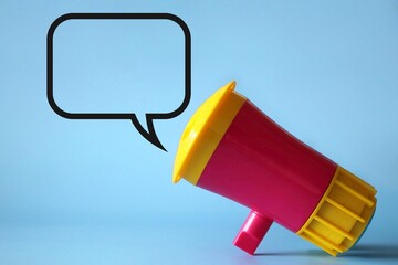 Megaphone, loudhailer on blue background with blank speech bubble. Copy space for text.